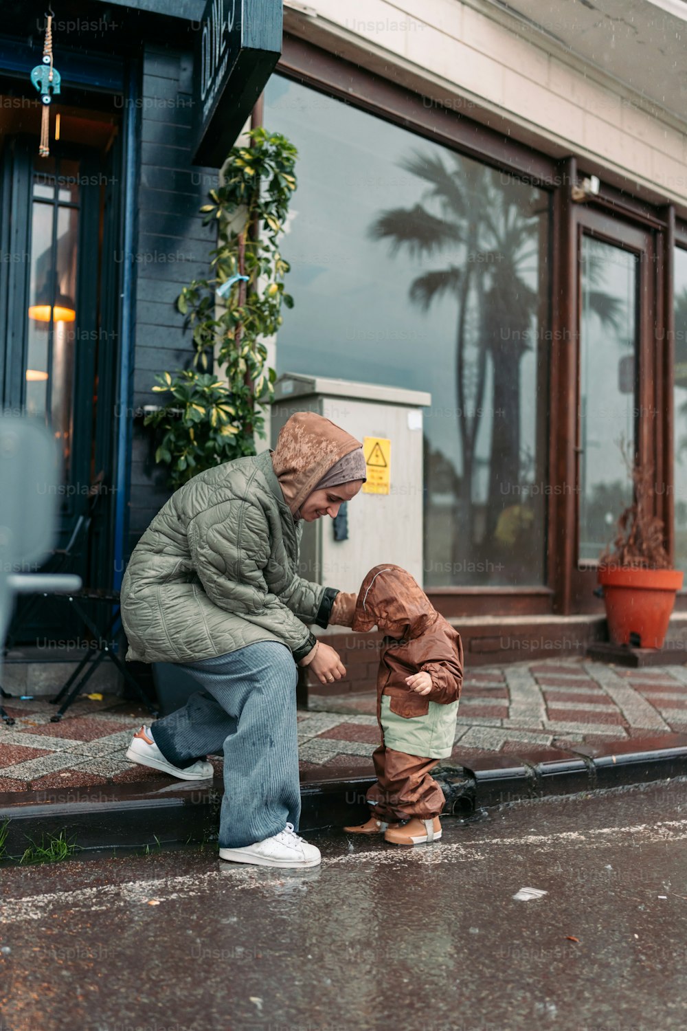 a man kneeling down next to a small child