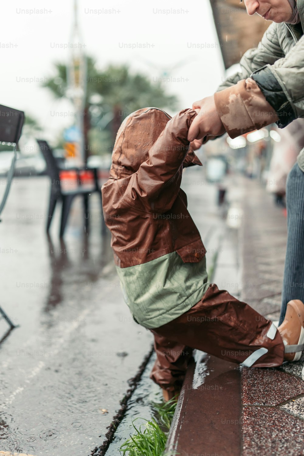 a small child standing on one foot in the rain