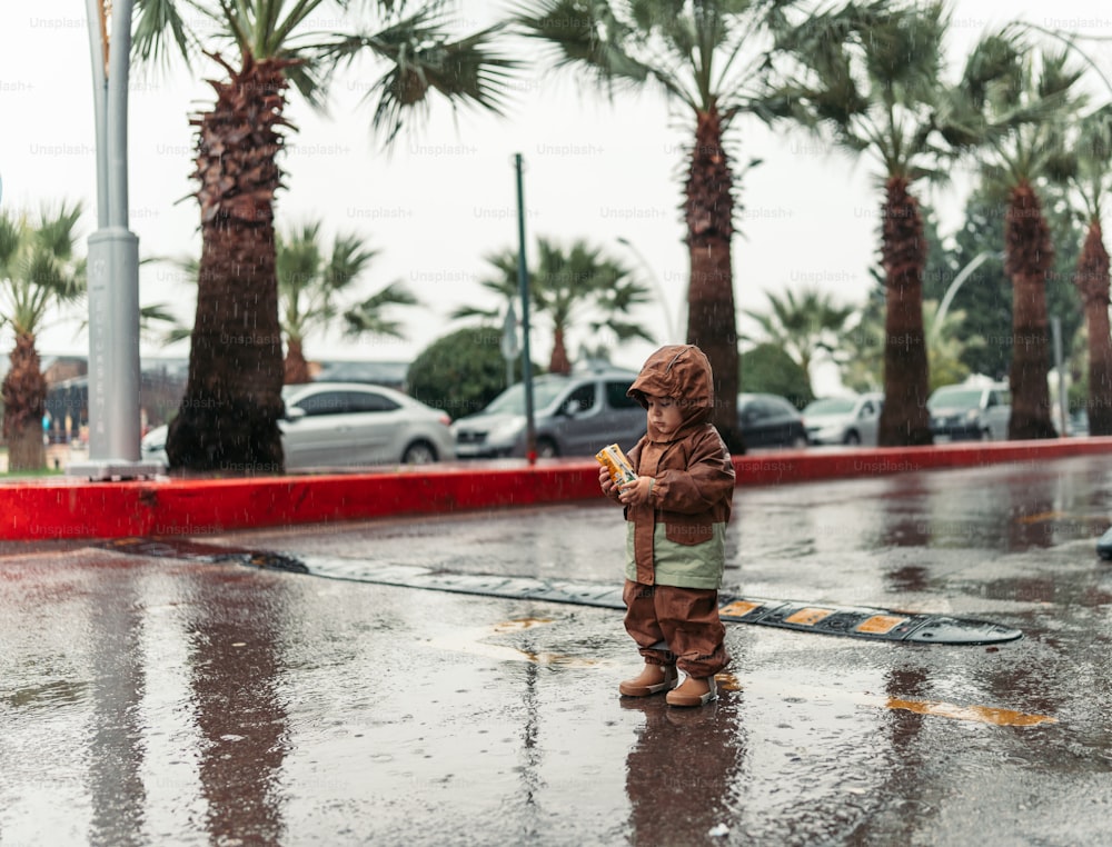 ein kleiner Junge, der im Regen steht
