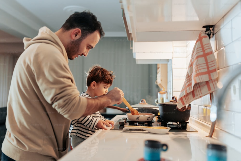 台所で料理をする男と子供