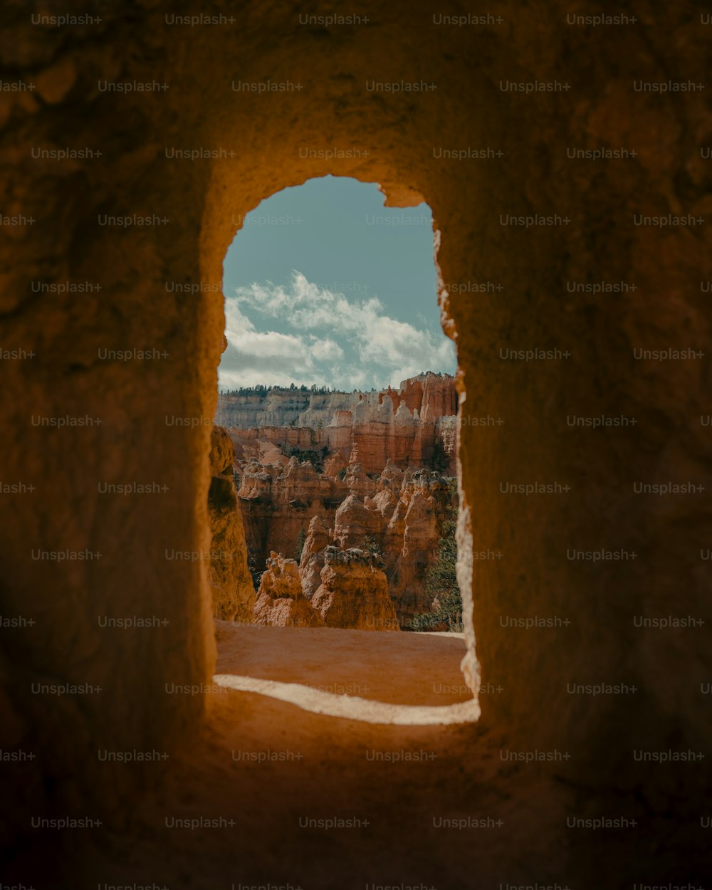 a window in a rock formation with a sky background