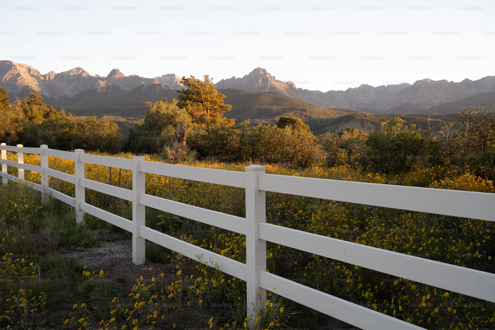 White vinyl fence stretching across an open field