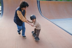 a man helping a child ride a skateboard on a ramp