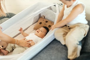 a baby laying in a crib next to a woman