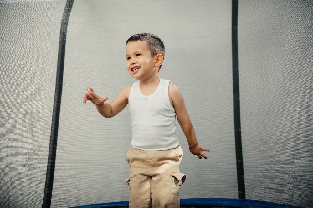 a young boy standing on top of a trampoline
