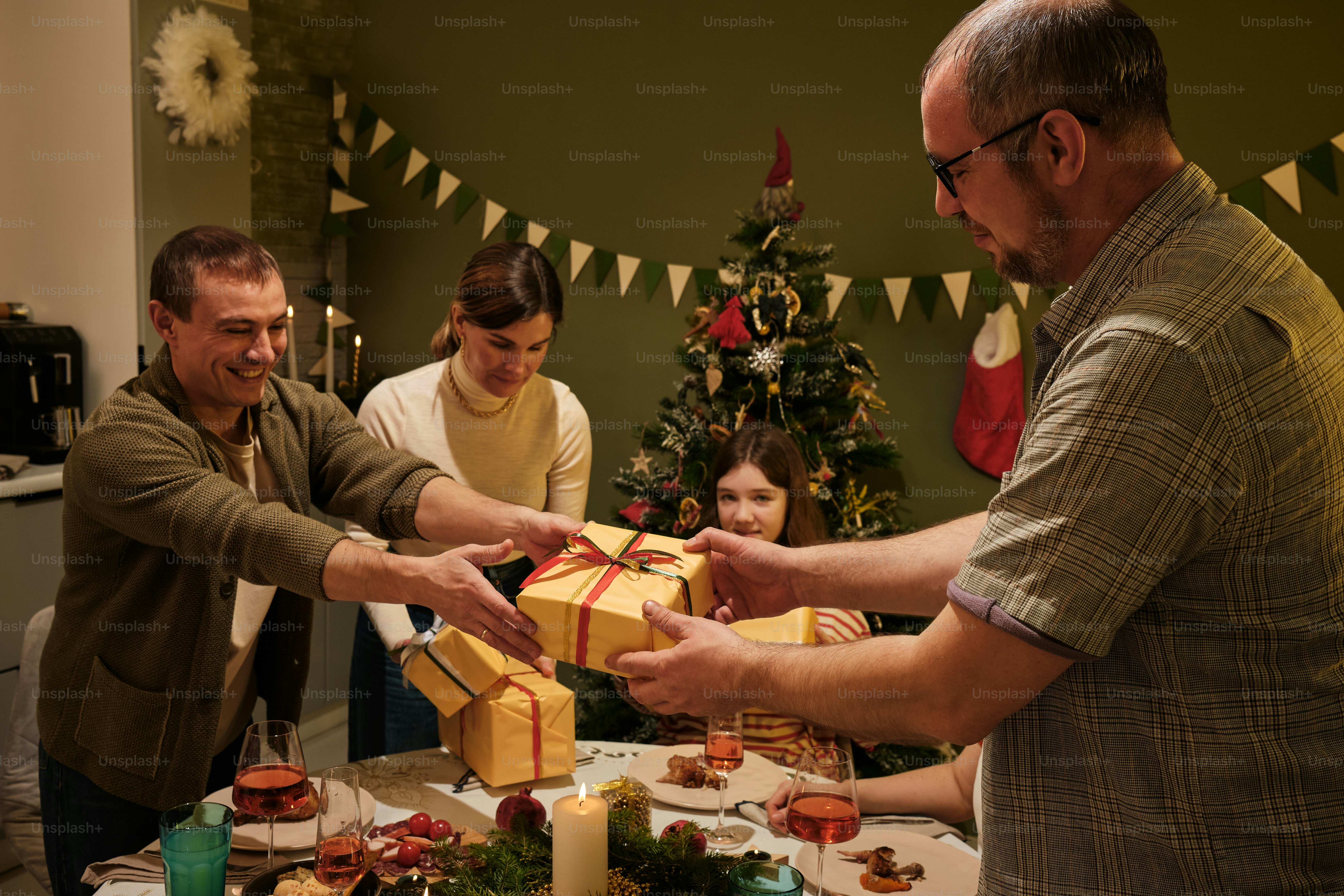 a group of people standing around a table with presents