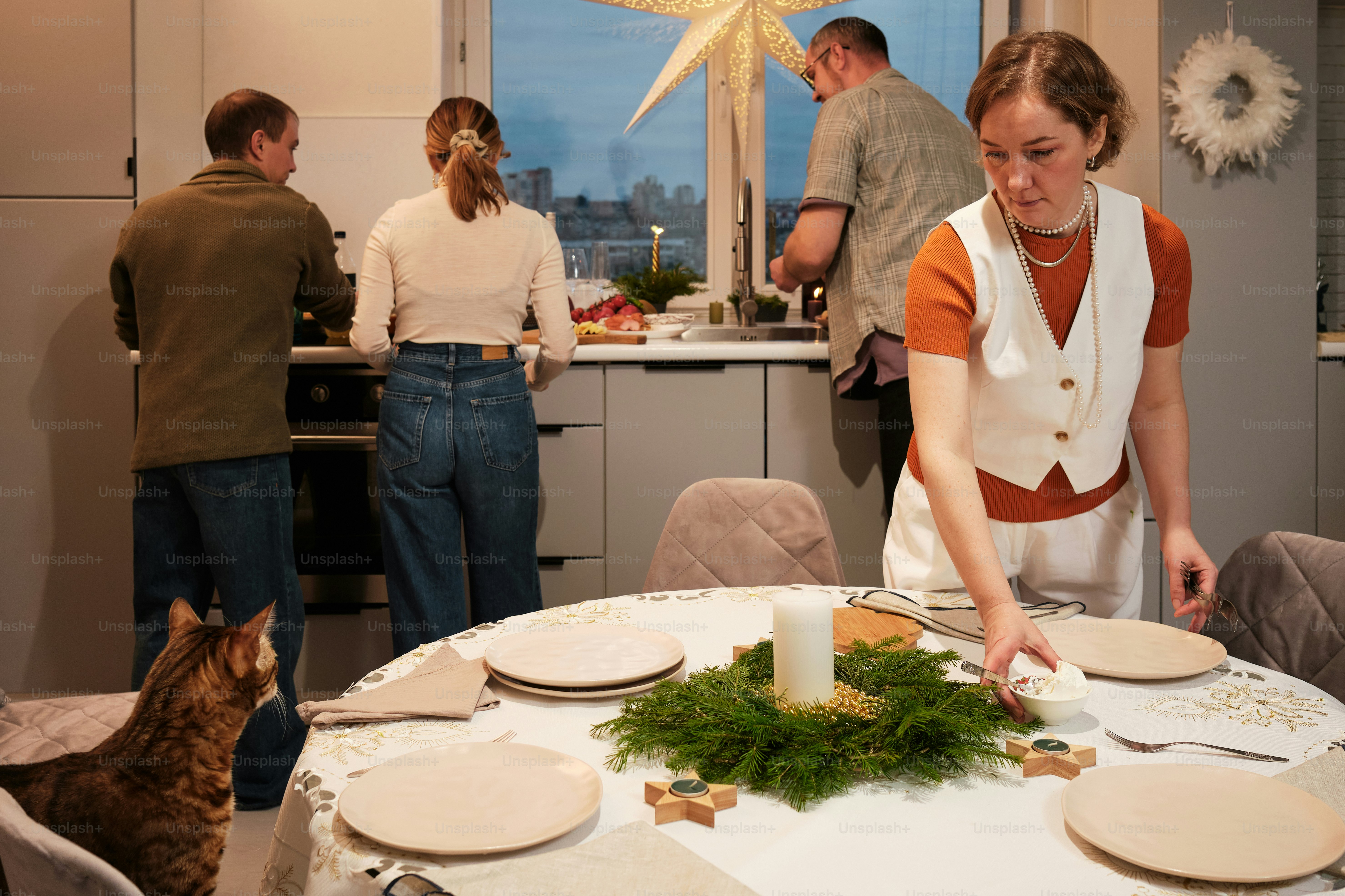 a group of people standing around a kitchen table