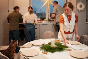 un grupo de personas de pie alrededor de una mesa de cocina