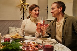 a man and a woman sitting at a table with a glass of wine