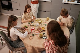 a group of children sitting around a table