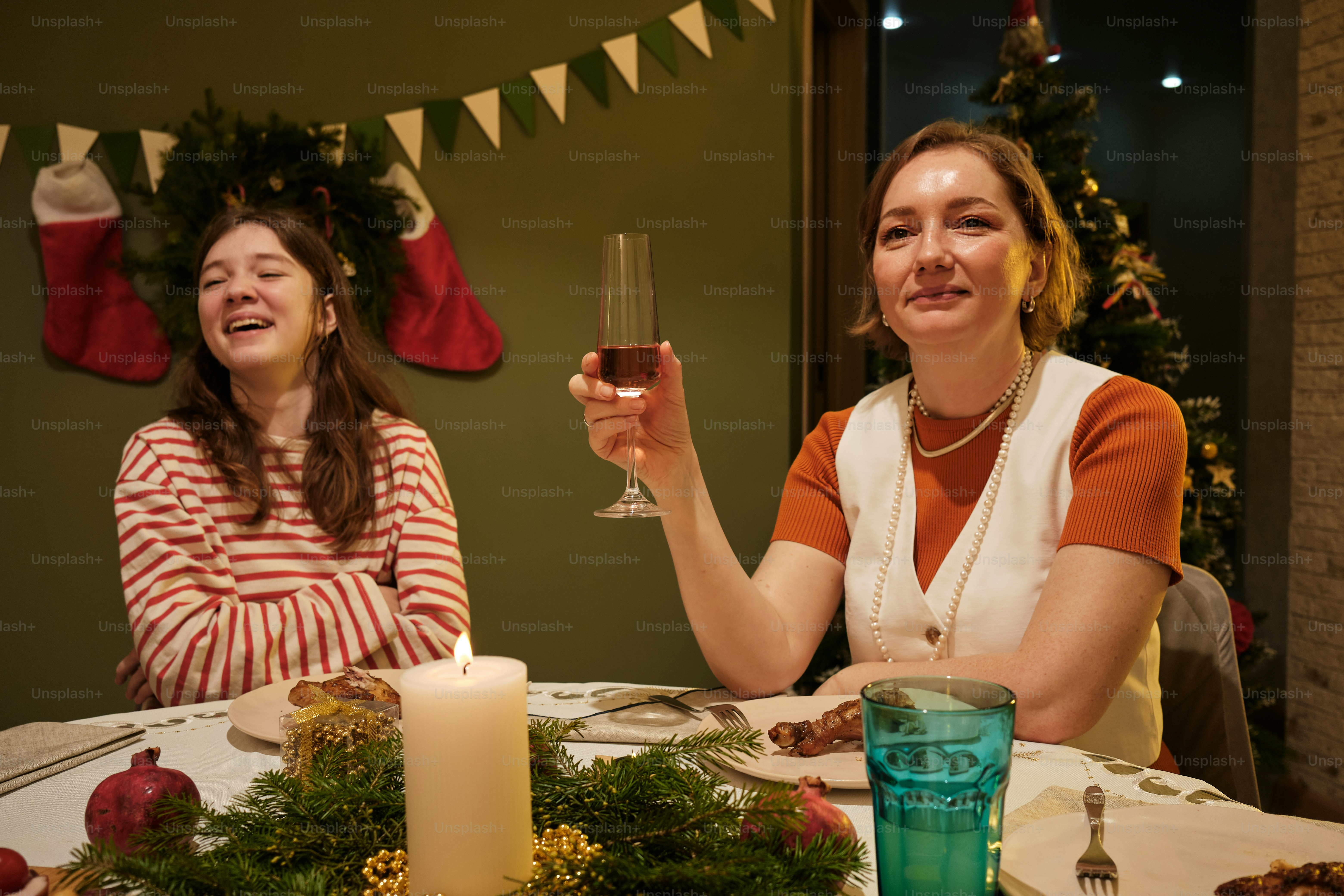 a couple of women sitting at a table with a glass of wine