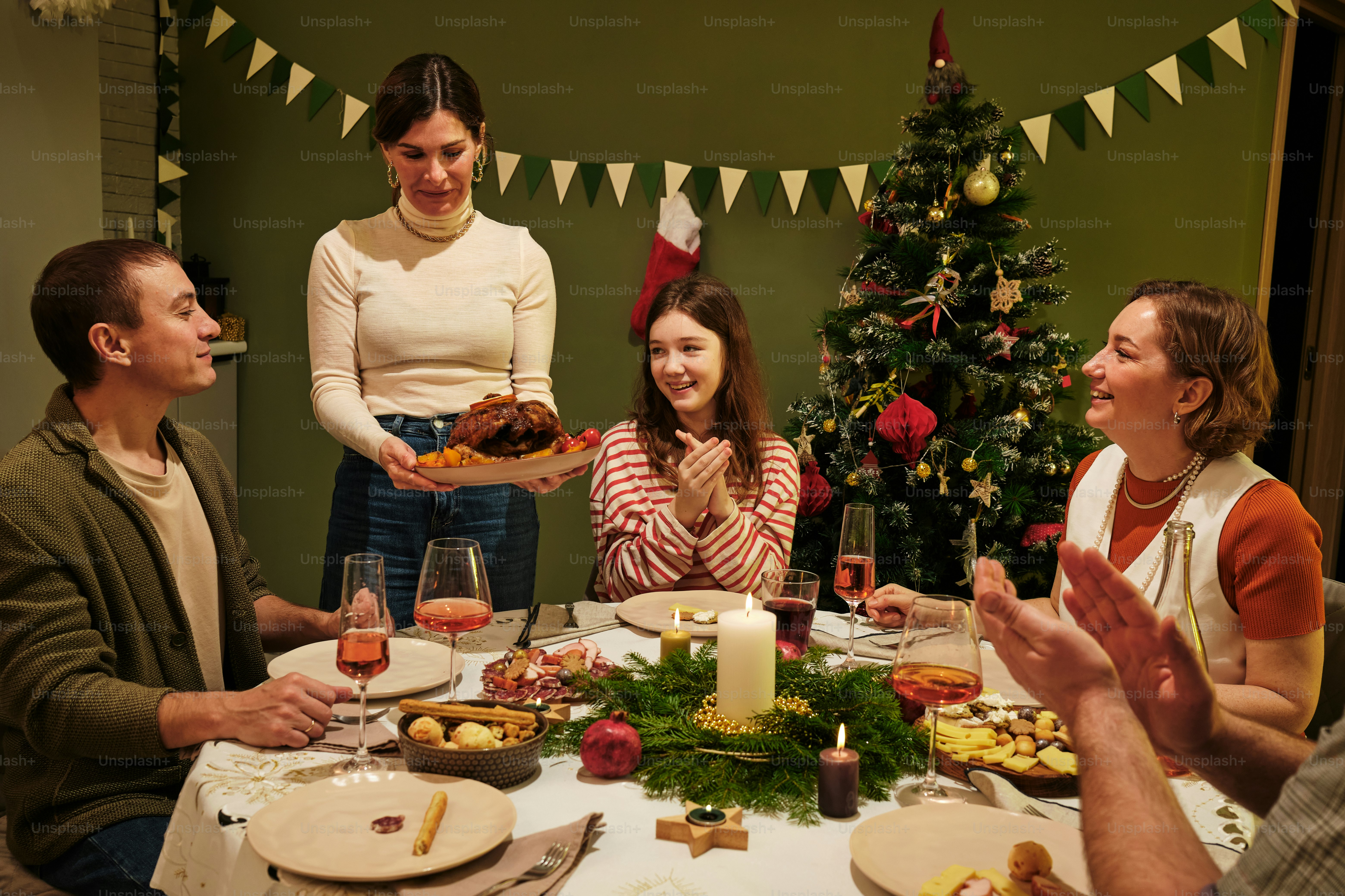 A group of people standing around a table with food photo – Christmas ...