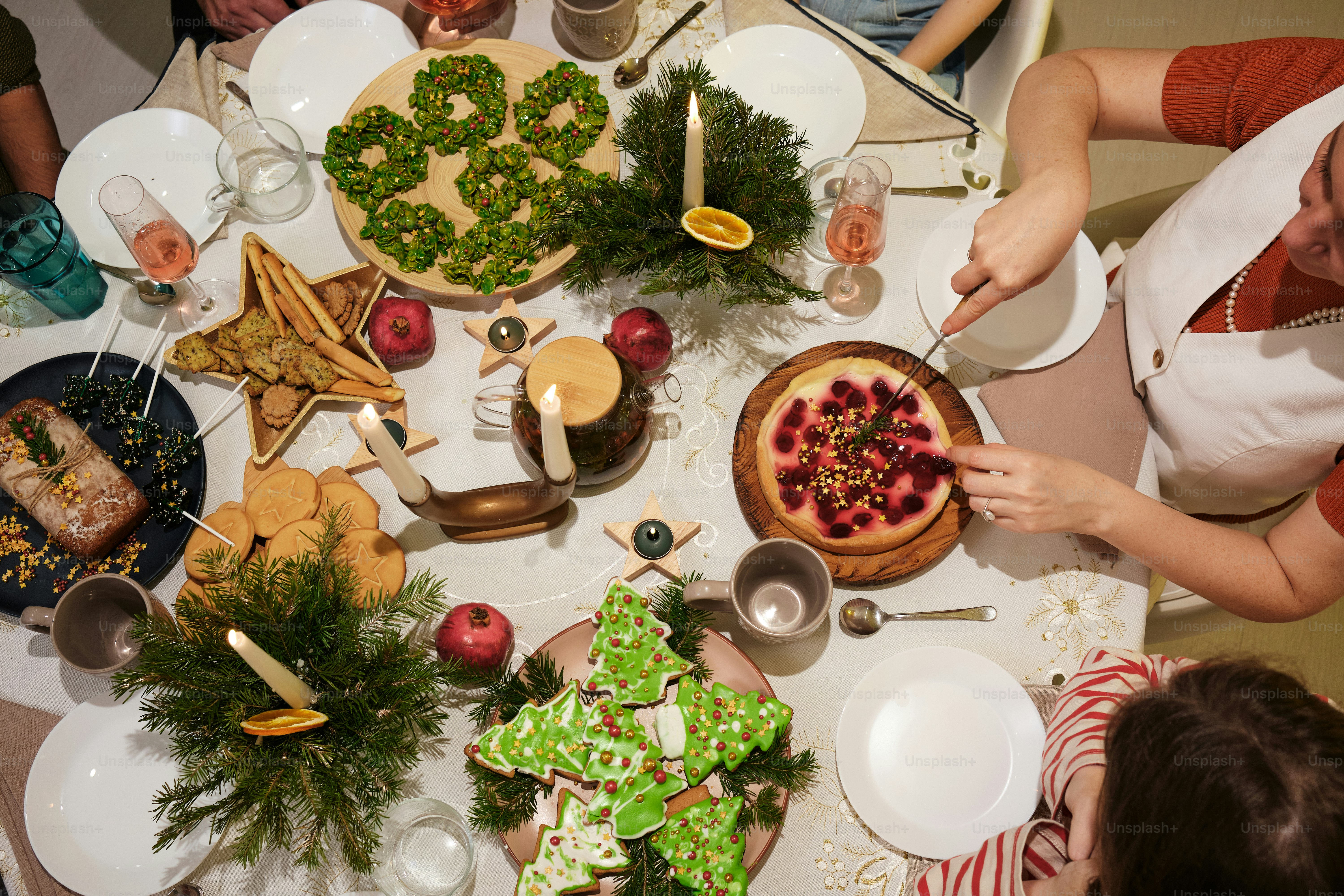 A group of people sitting around a table with food photo – Christmas ...