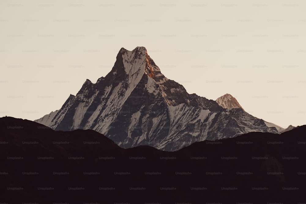 La cima de una montaña se recorta contra un cielo gris