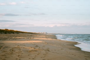 Une plage de sable fin au bord de l’océan sous un ciel nuageux