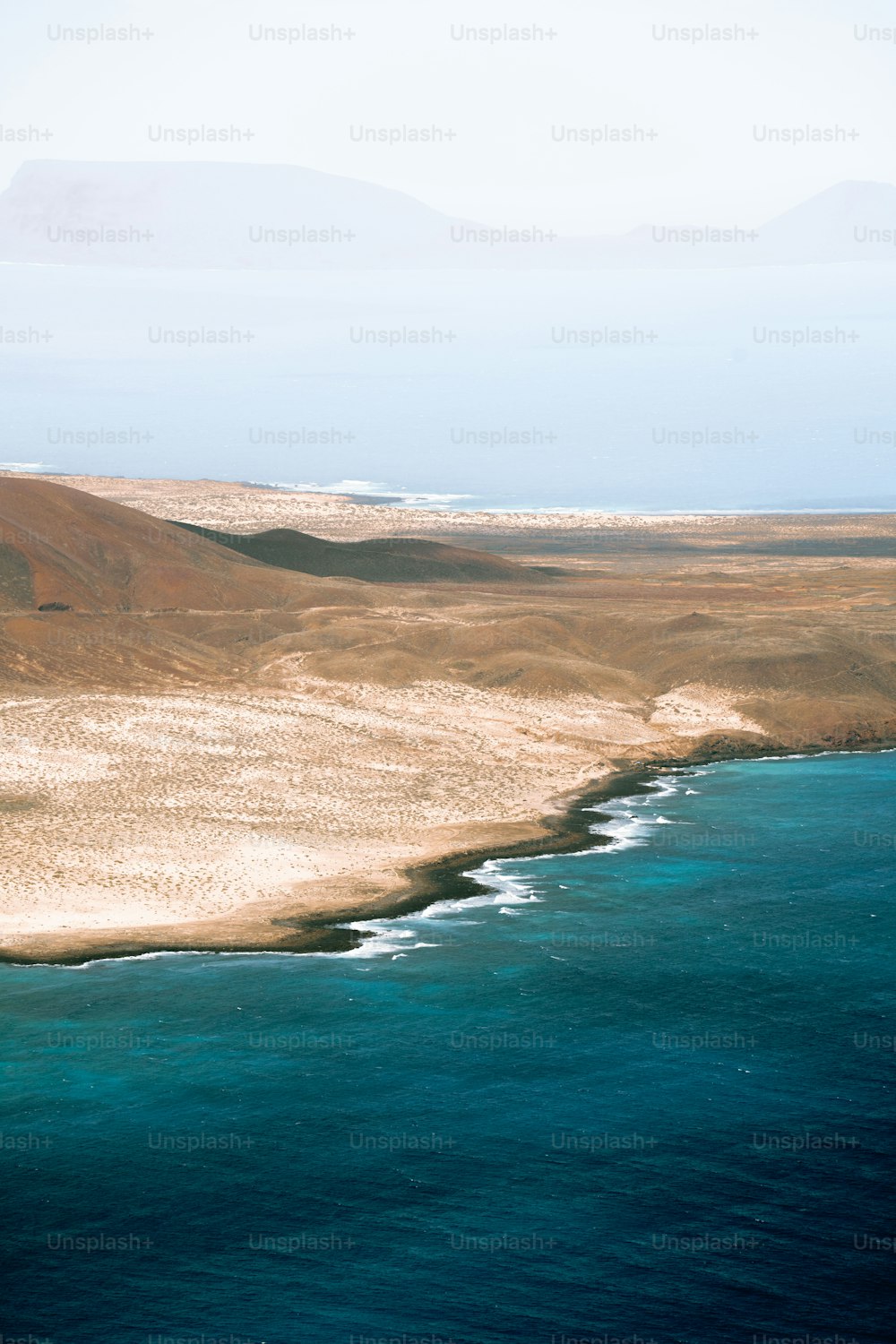 a large body of water sitting next to a sandy beach