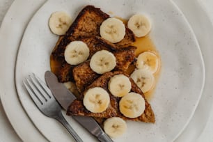 a white plate topped with french toast and bananas