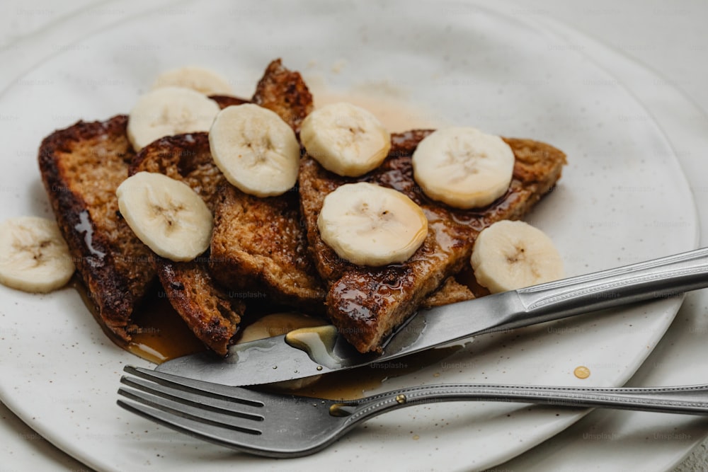 Un piatto bianco condito con toast alla francese e banane