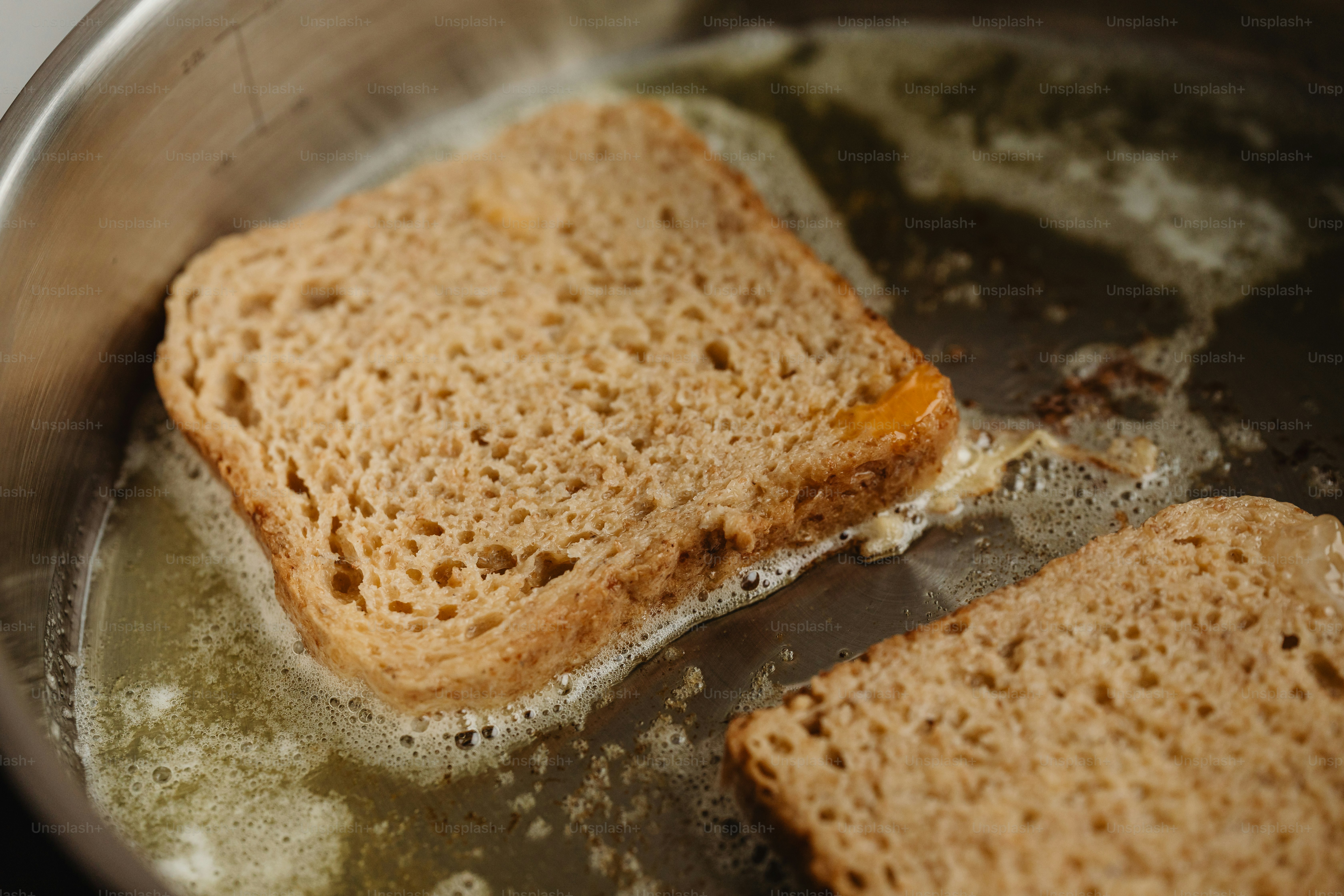 Two pieces of bread are being cooked in a pan photo – Food Image on ...