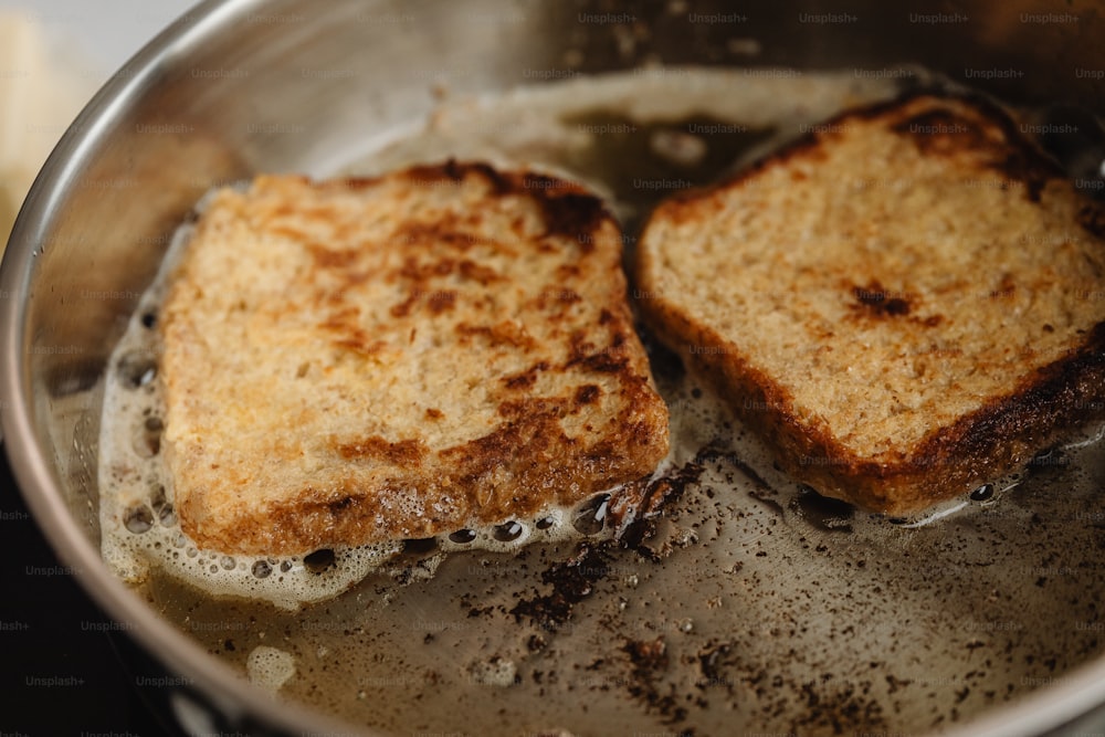 two pieces of toast are cooking in a pan