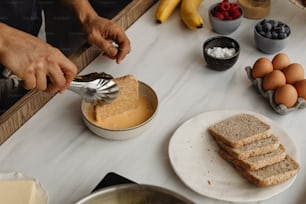 a person spreading peanut butter on a piece of bread