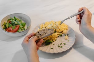 a person holding a spoon over a plate of food