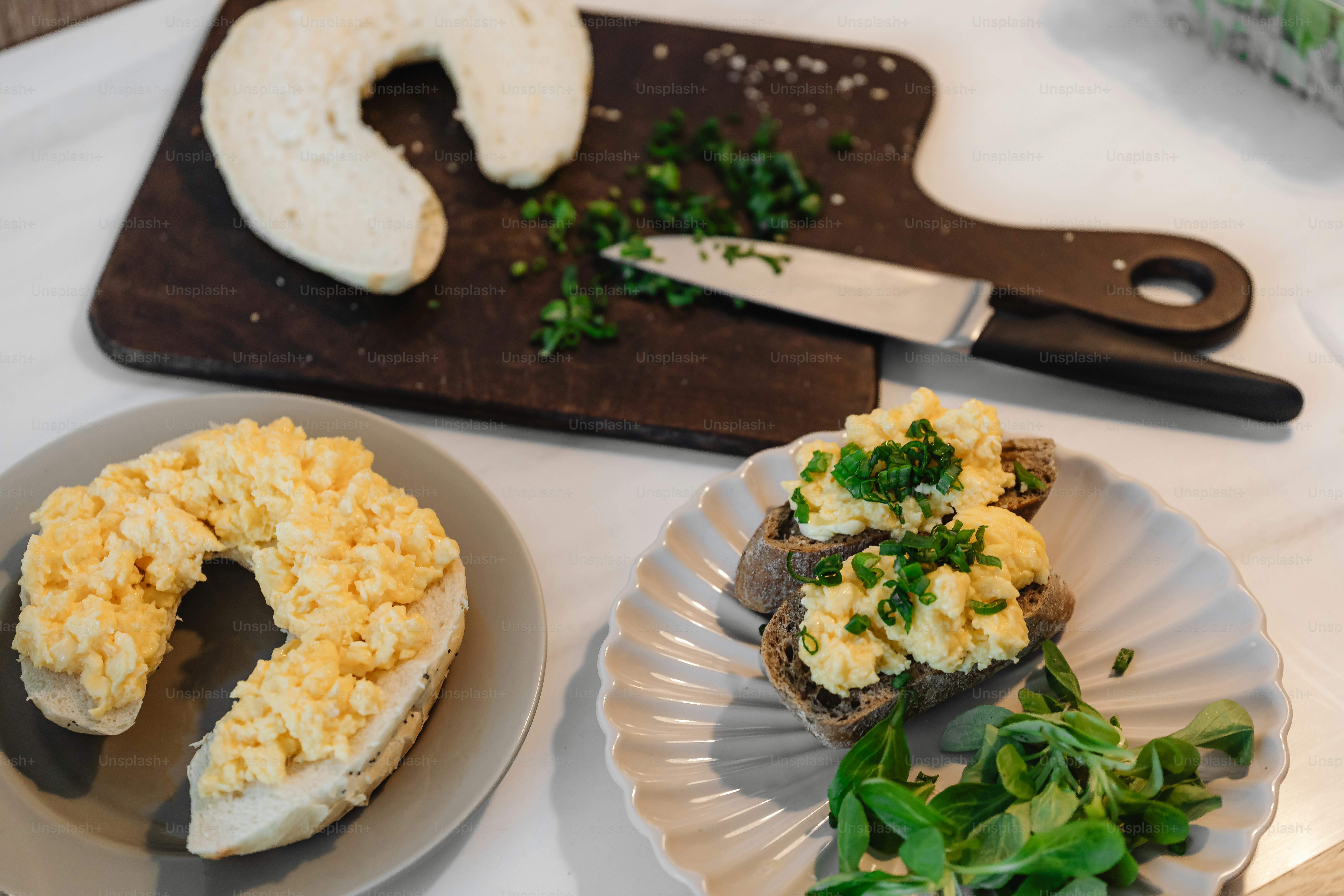 a table topped with plates of food and a cutting board