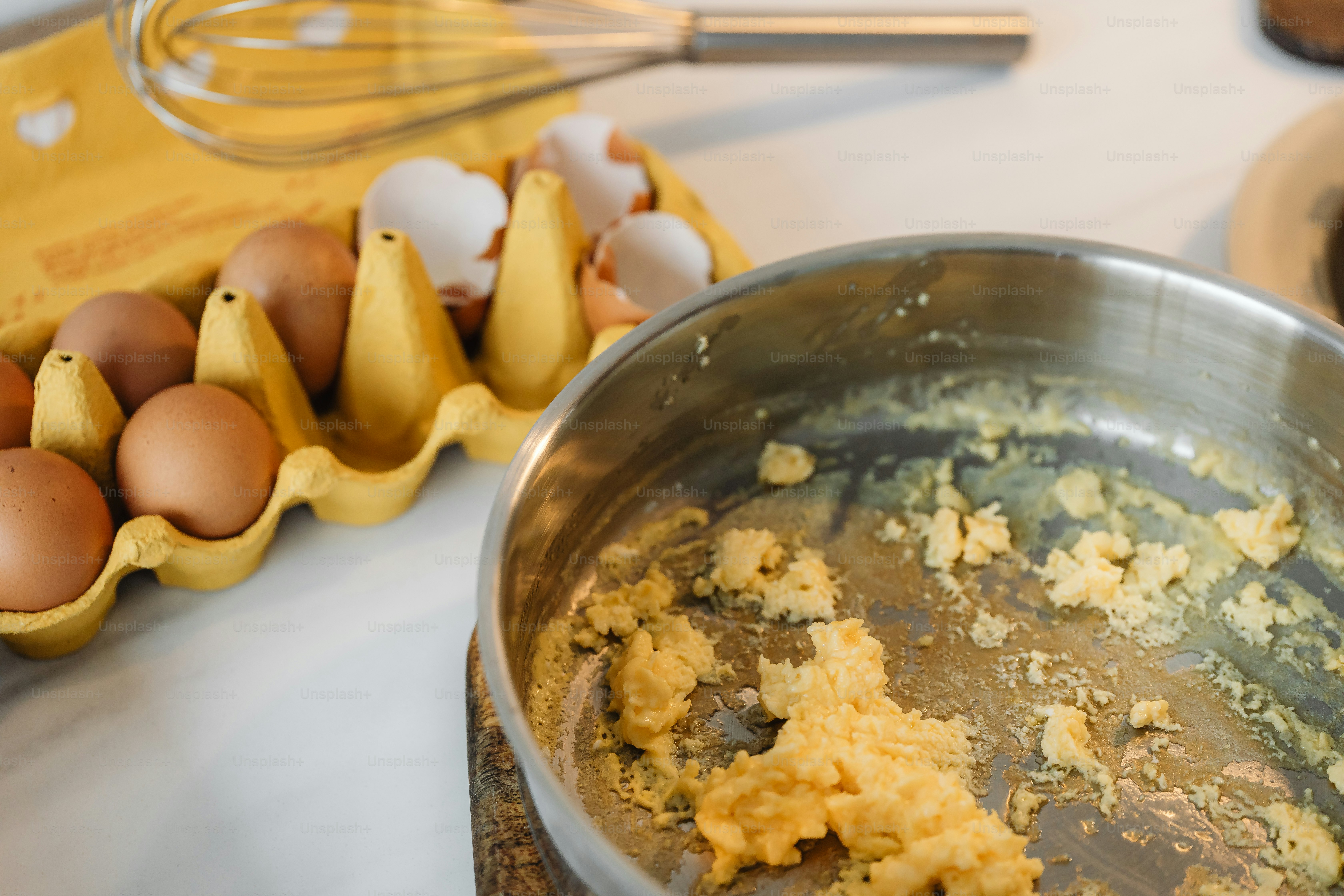 a metal bowl filled with food next to eggs
