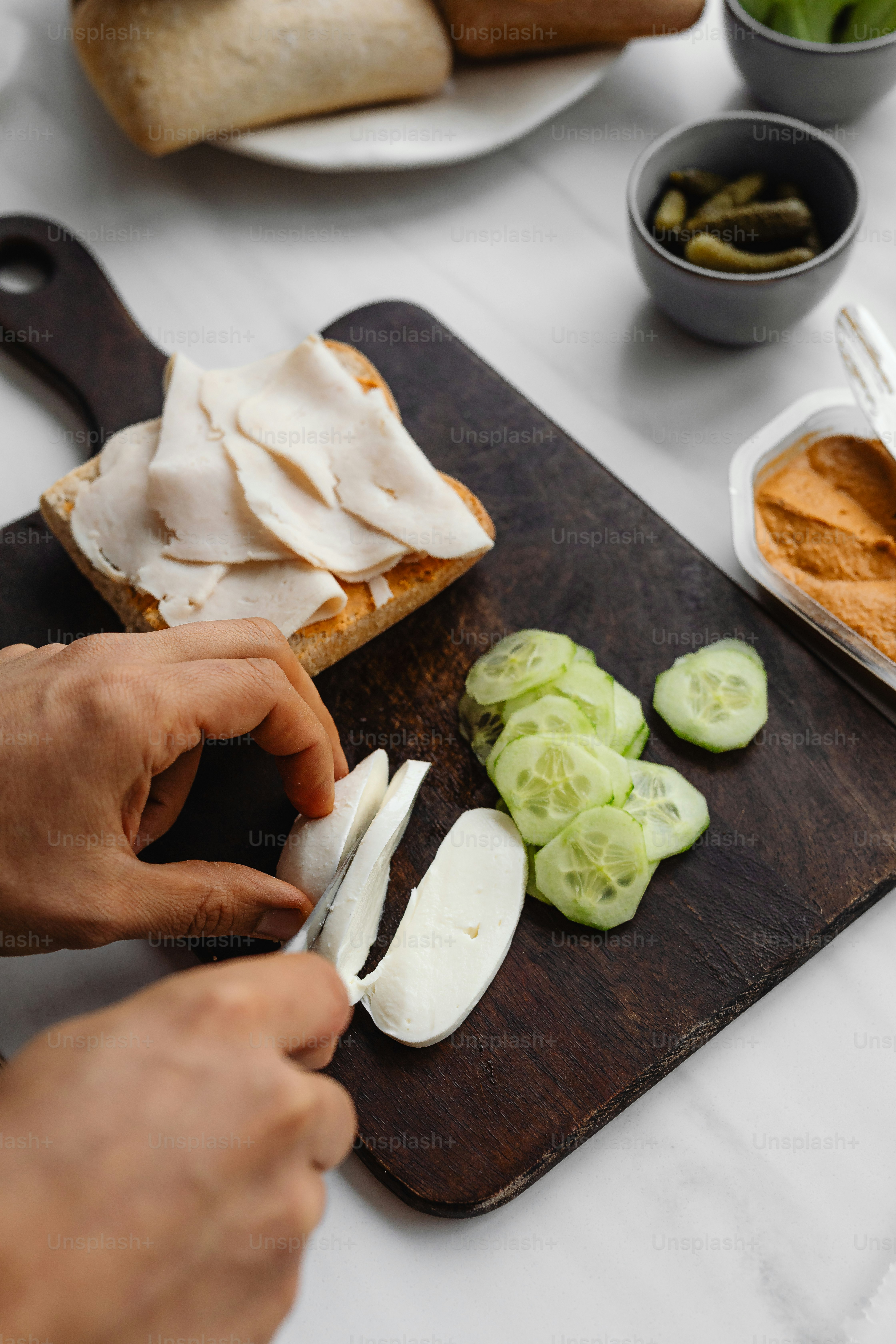 a person cutting up food on a cutting board