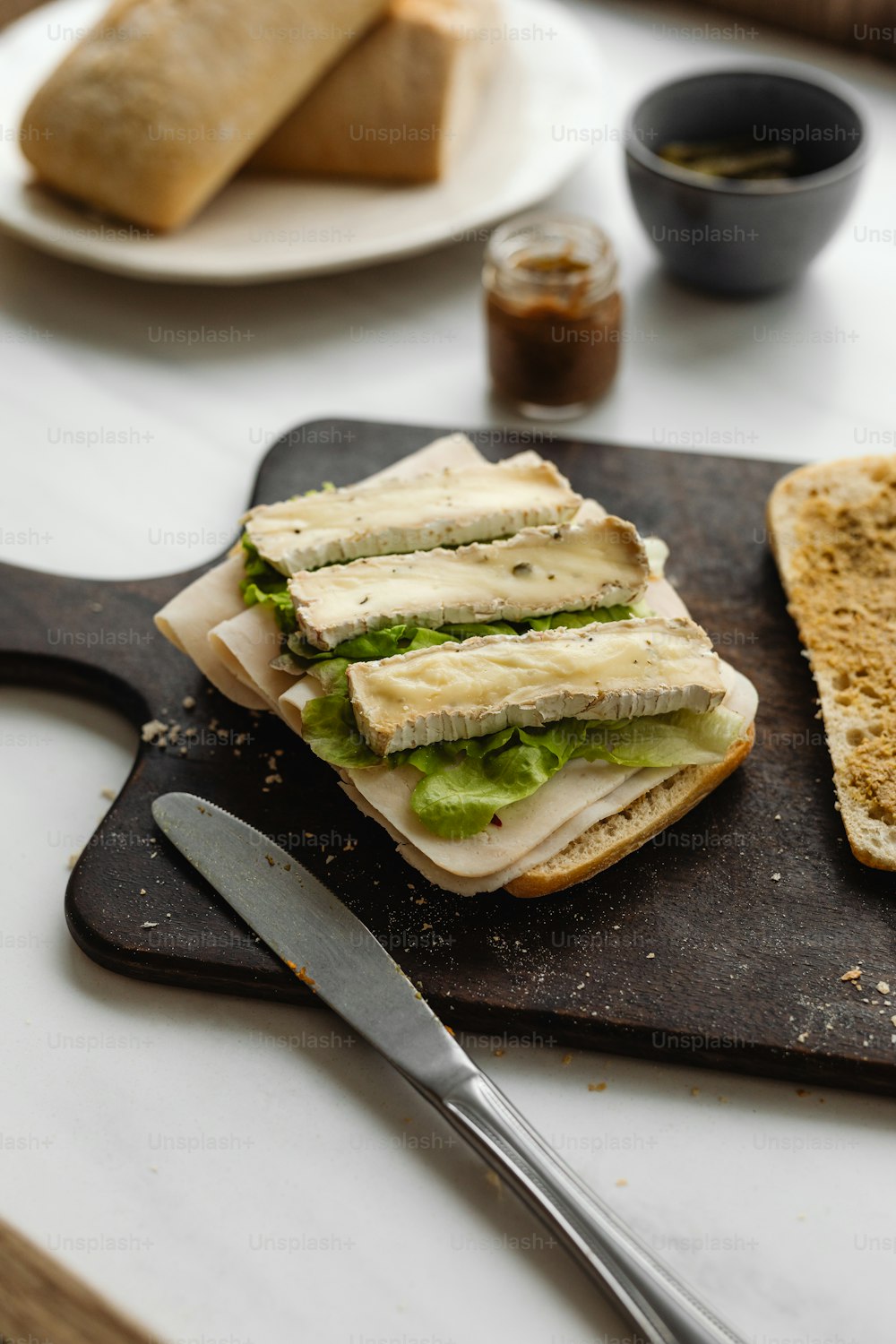 a sandwich on a cutting board with a knife