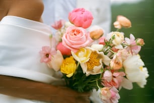 eine Braut, die einen Blumenstrauß in den Händen hält