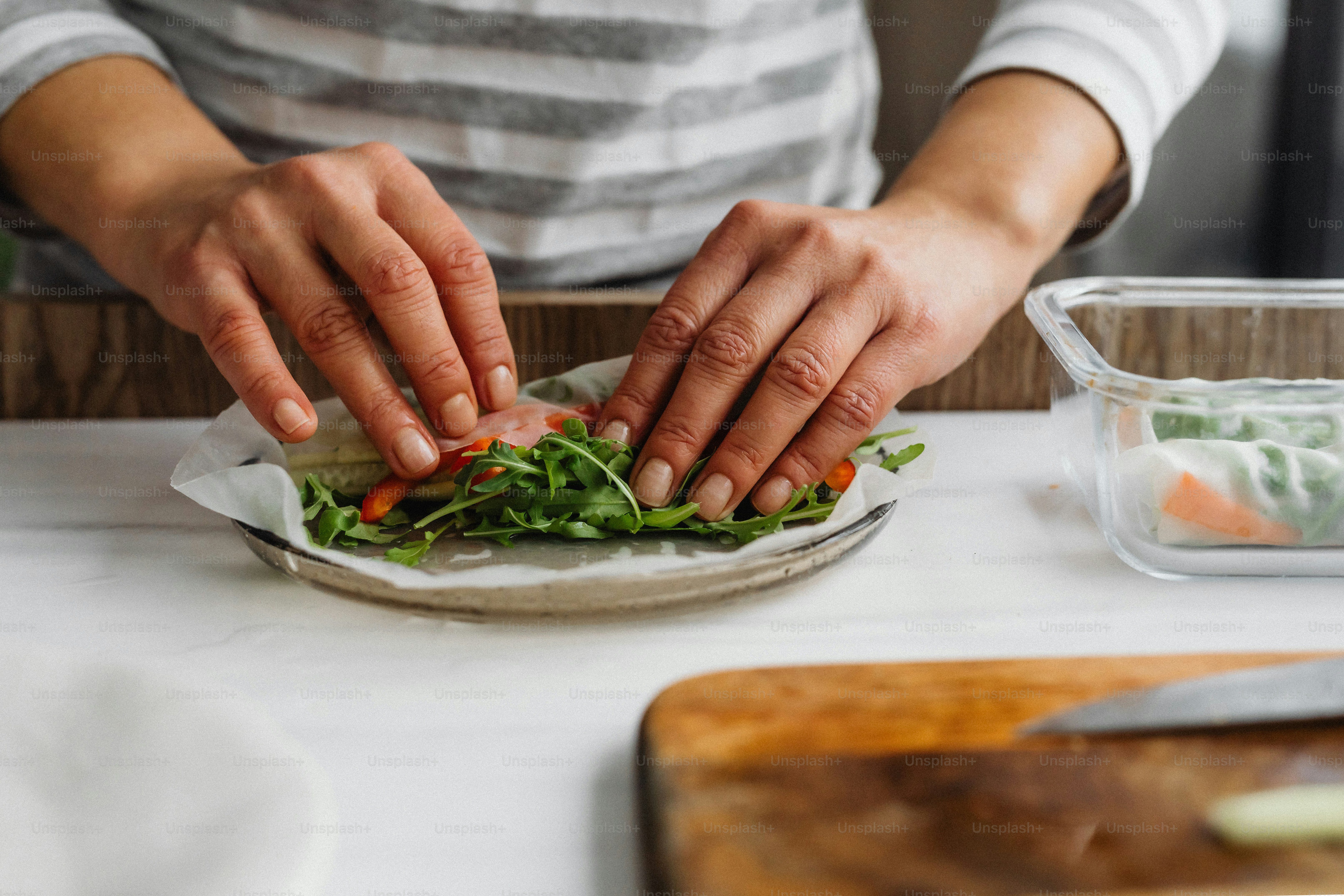 a person with their hands on a plate of food