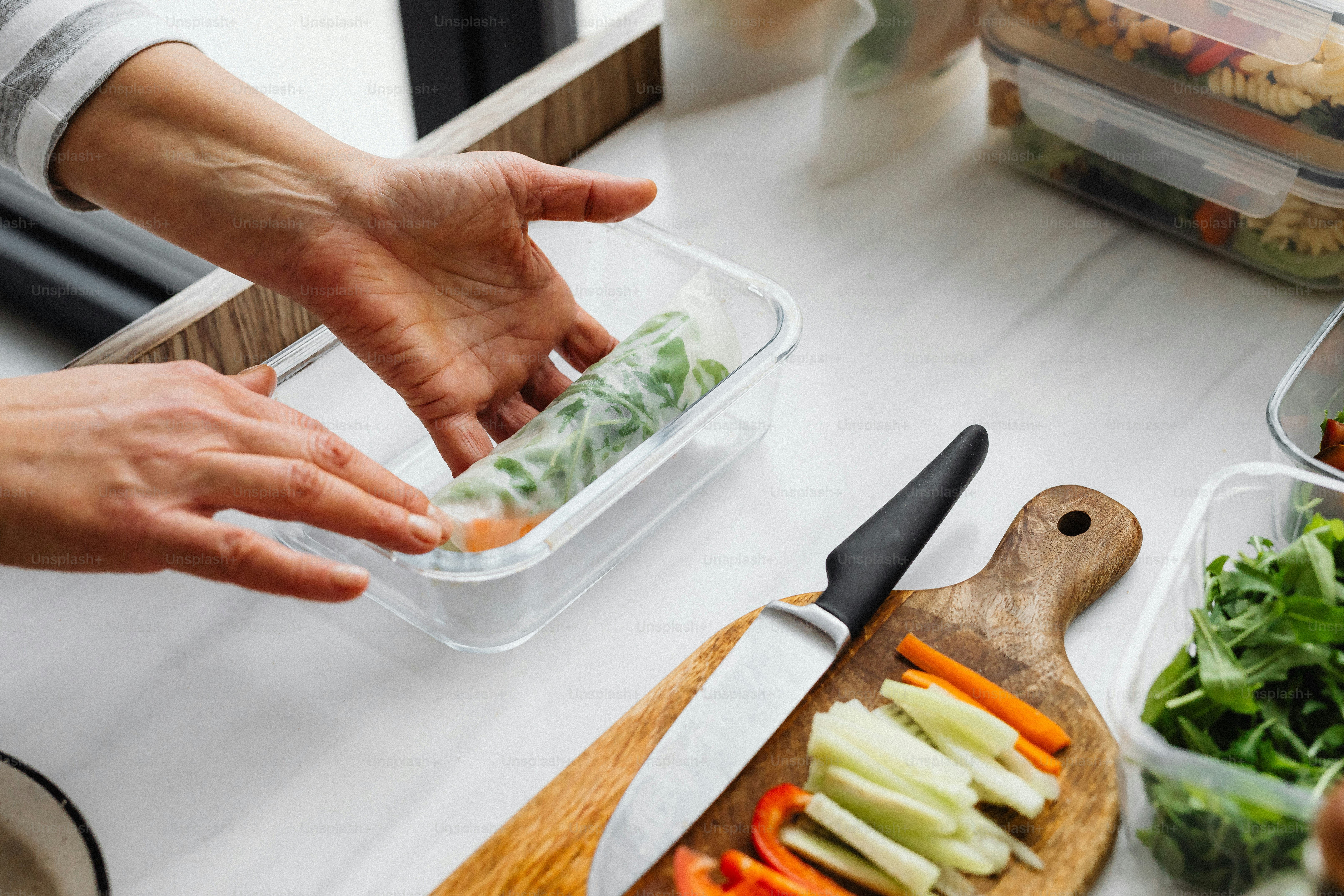 a person is putting food in a container