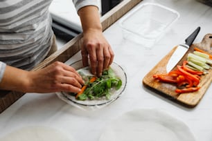 a person cutting vegetables on a cutting board