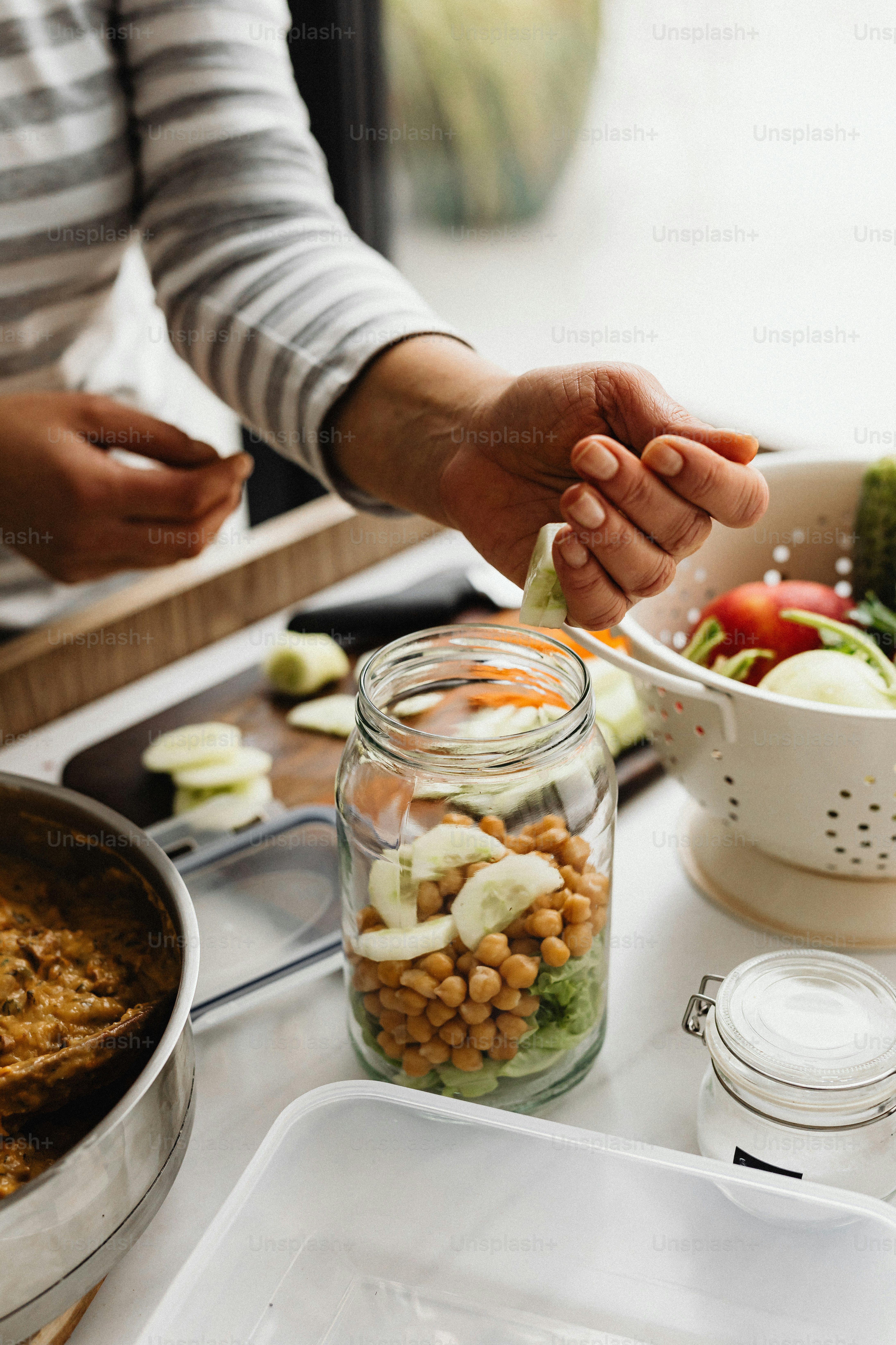 a person putting a spoon in a jar of food