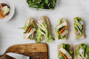 a table topped with sandwiches covered in lettuce and carrots