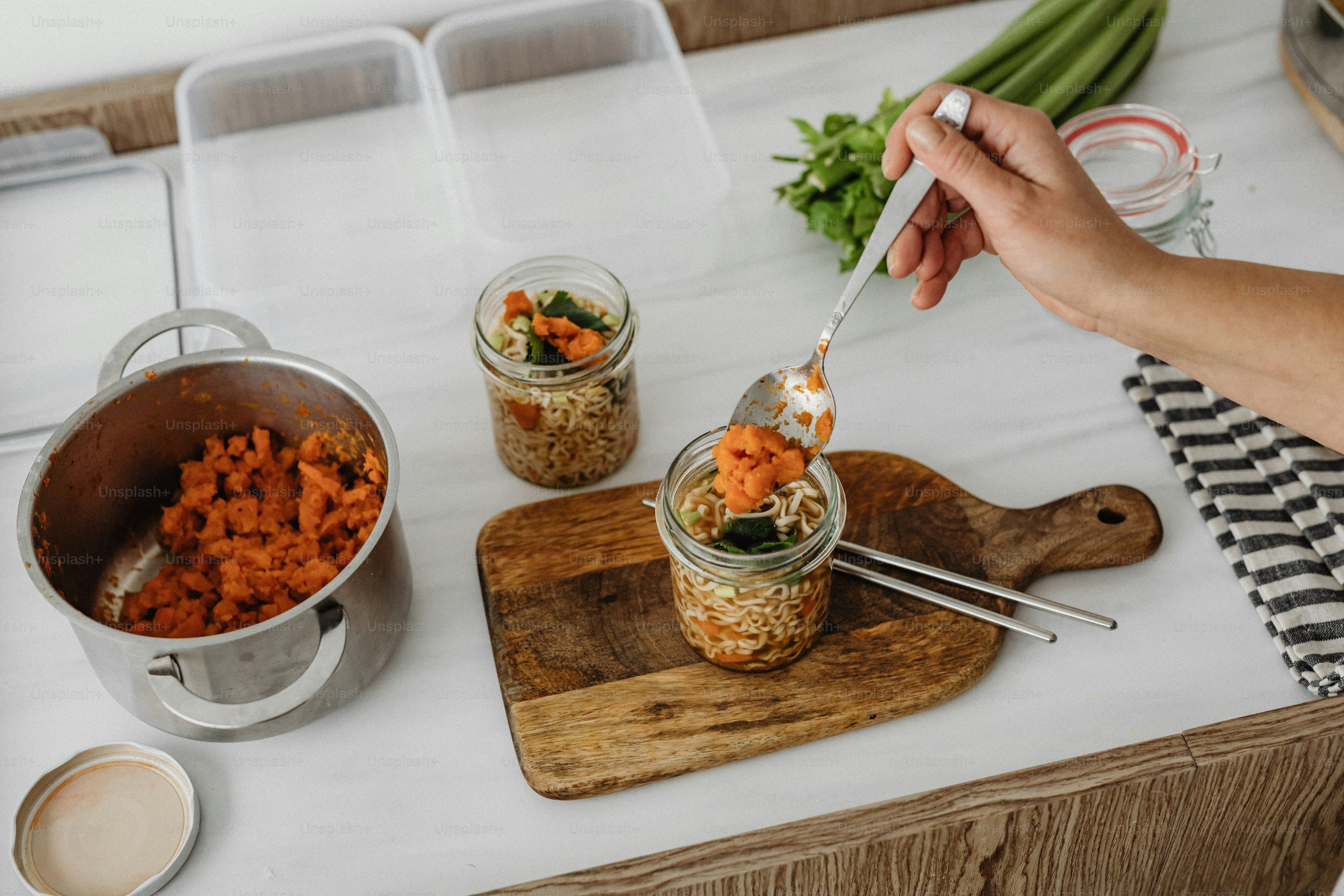 a person holding a spoon over a jar of food