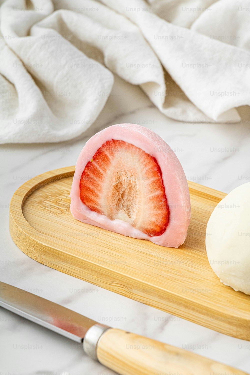 a sliced strawberry sitting on top of a wooden cutting board