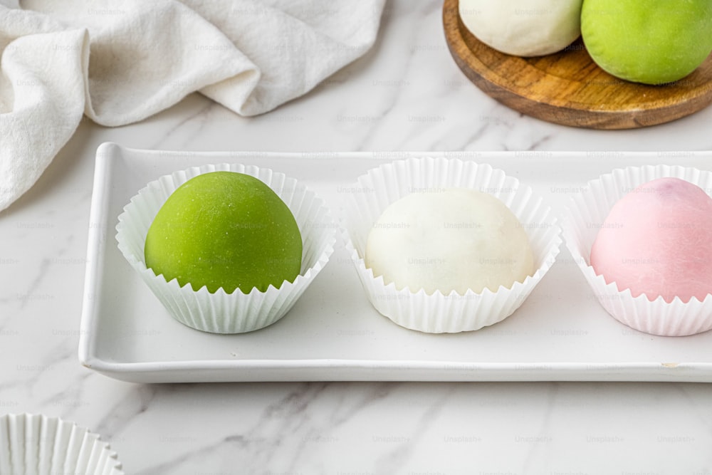 drei verschiedenfarbige Desserts auf weißem Tablett