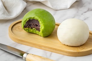 a green ball of food sitting on top of a wooden cutting board