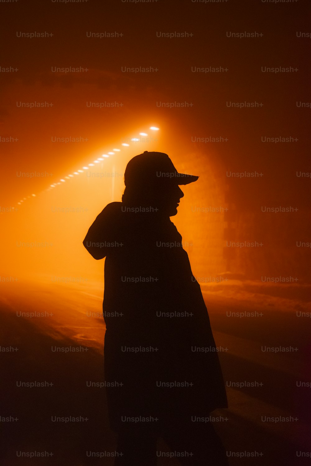 a person standing in the fog with a hat on