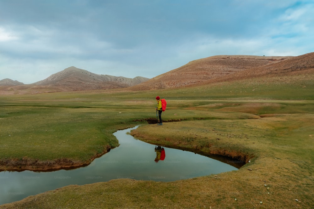 a person in a red jacket standing on a green field