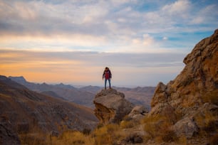 a person standing on top of a large rock