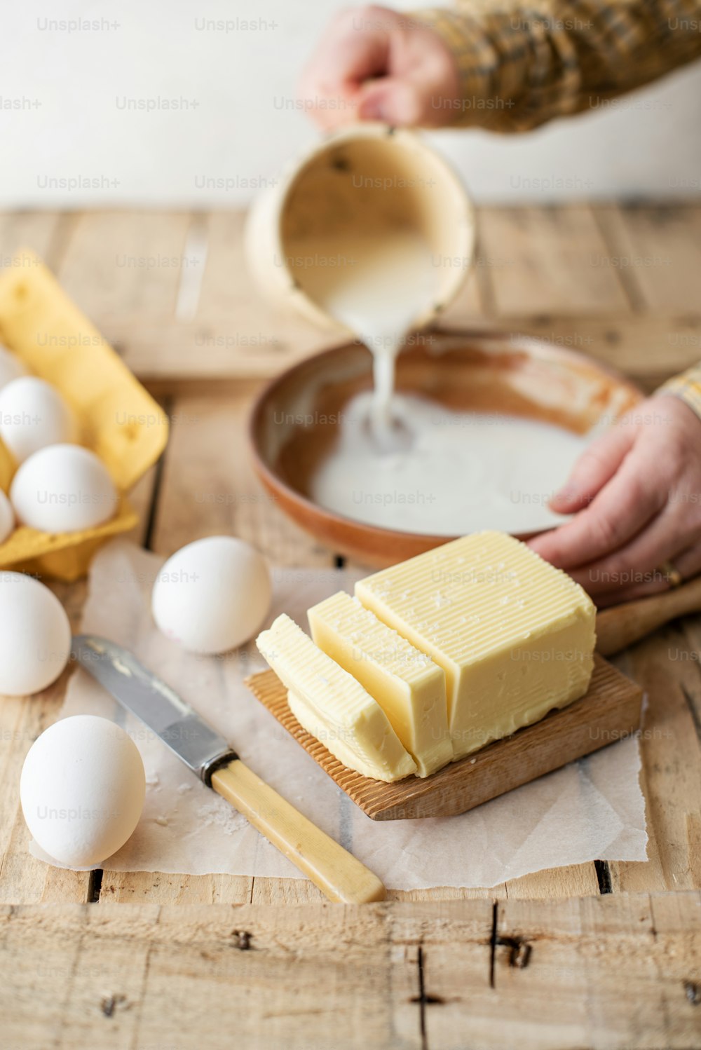 Eine Person streicht Butter auf ein Stück Brot