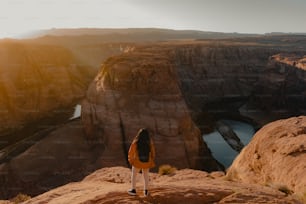 a woman standing on top of a large cliff