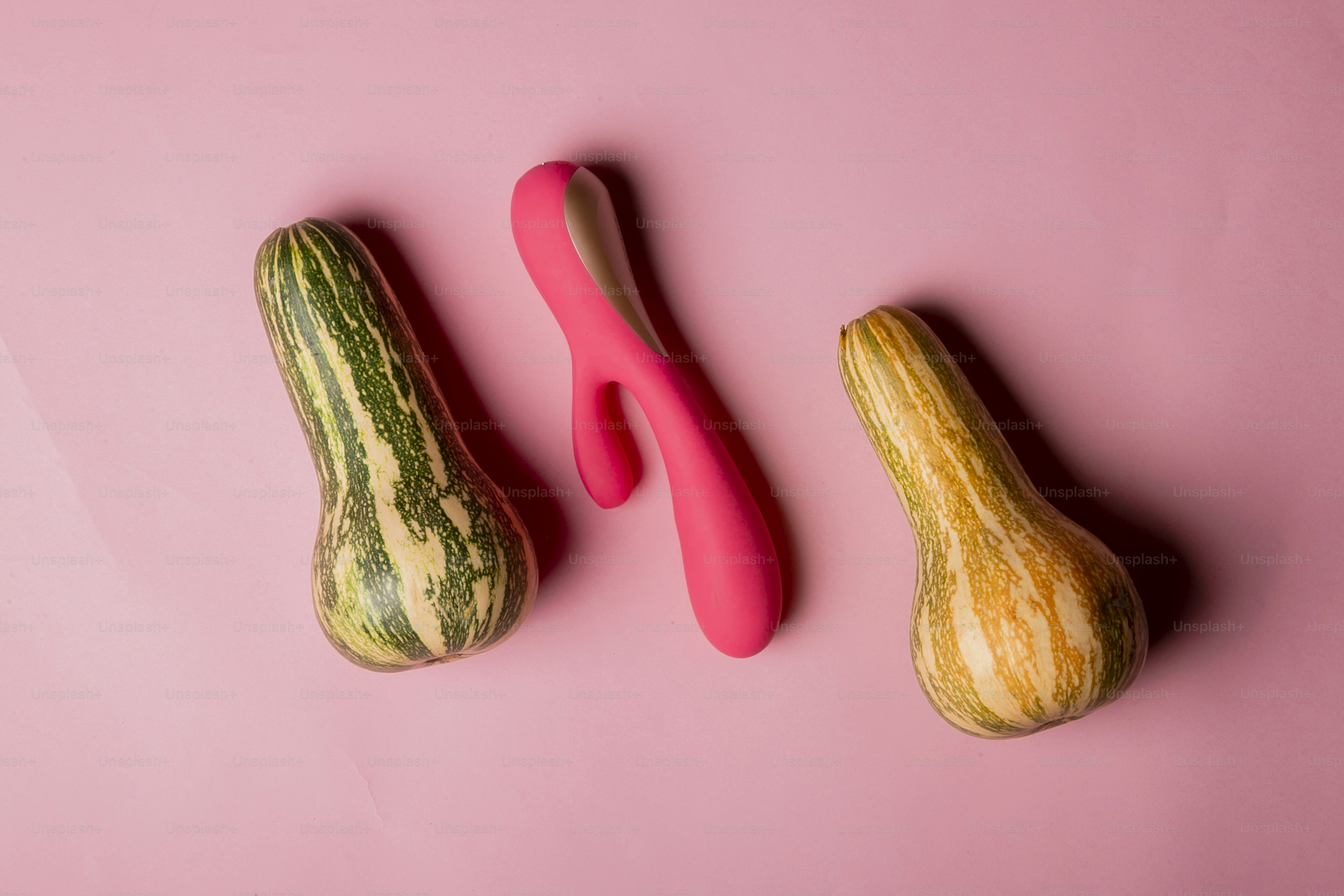 a couple of gourds sitting on top of a pink surface