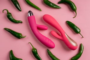 a group of green and pink peppers on a pink surface