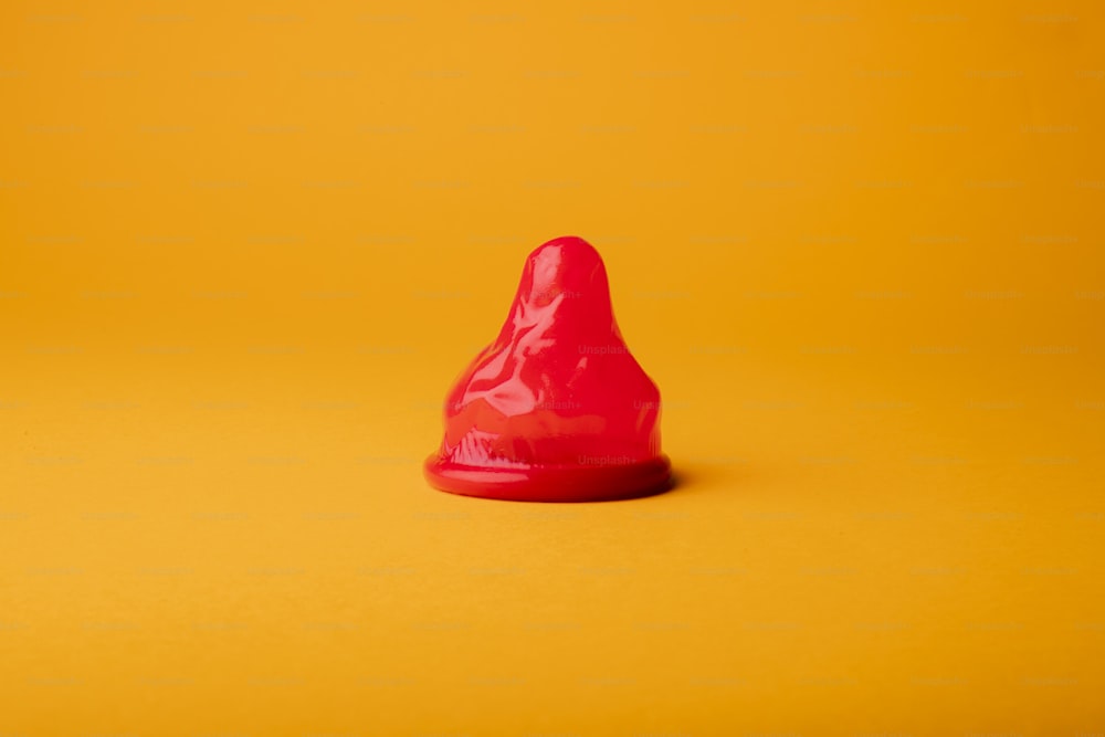 a red cone sitting on top of a yellow surface