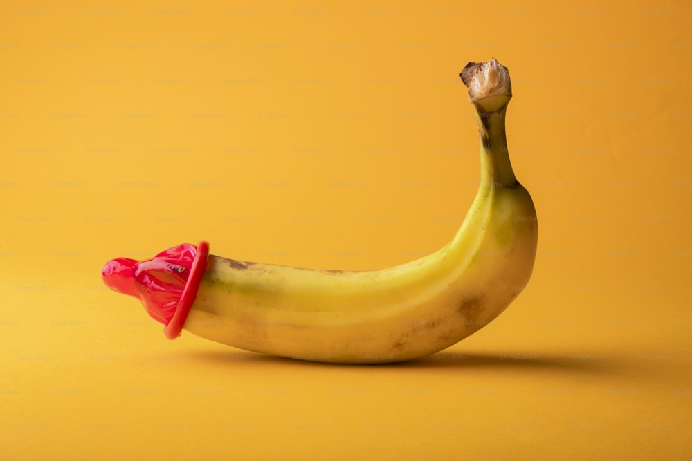 uma banana com um laço vermelho