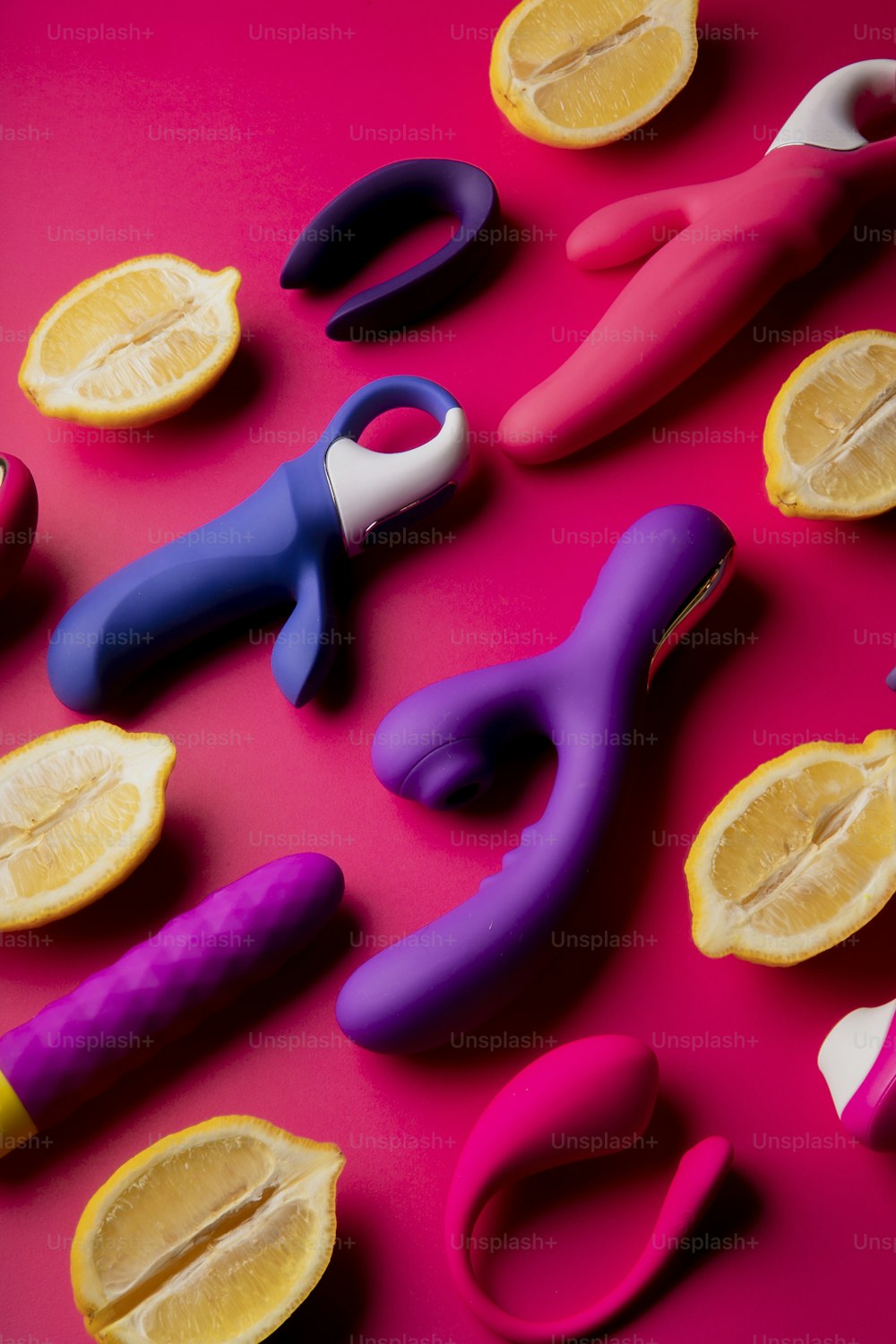 a group of scissors and lemon slices on a pink surface